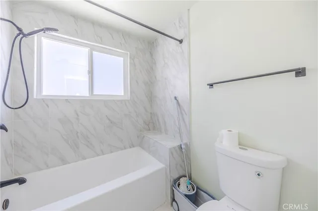 a bathroom with a bathtub a window and a shower