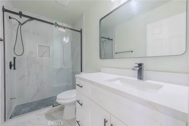 a bathroom with a sink a toilet and shower