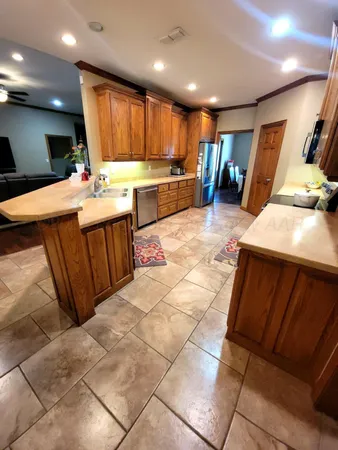 a large kitchen with stainless steel appliances kitchen island granite countertop a sink and cabinets