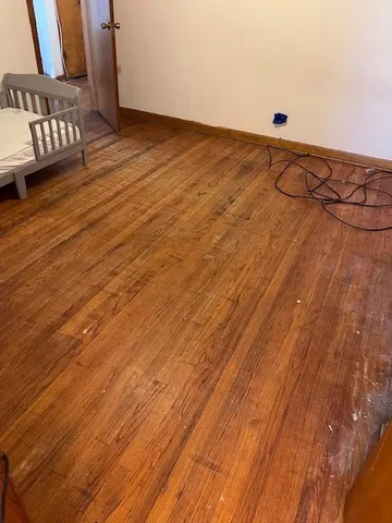 a view of an empty room with wooden floor