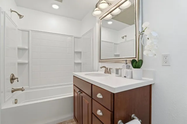a bathroom with a sink vanity tub and shower