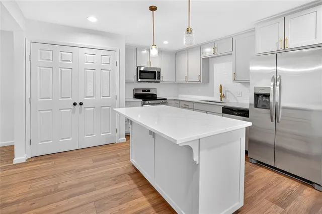 a kitchen with white cabinets and stainless steel appliances