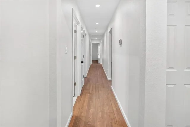 a view of a hallway with wooden floor and staircase