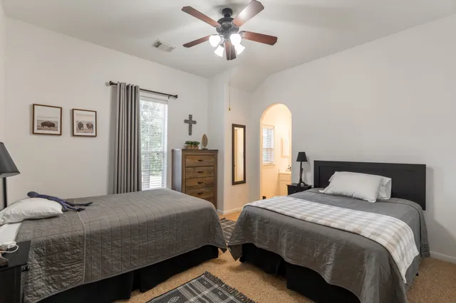 a bedroom with two beds and a chandelier