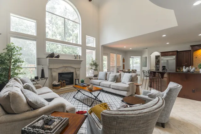 a living room with furniture fireplace and a large window
