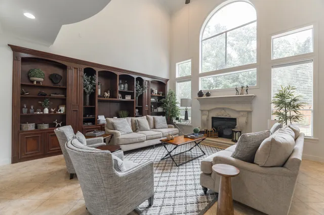 a living room with furniture a fireplace and a large window