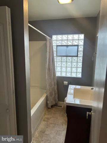 a bathroom with a bathtub sink and window