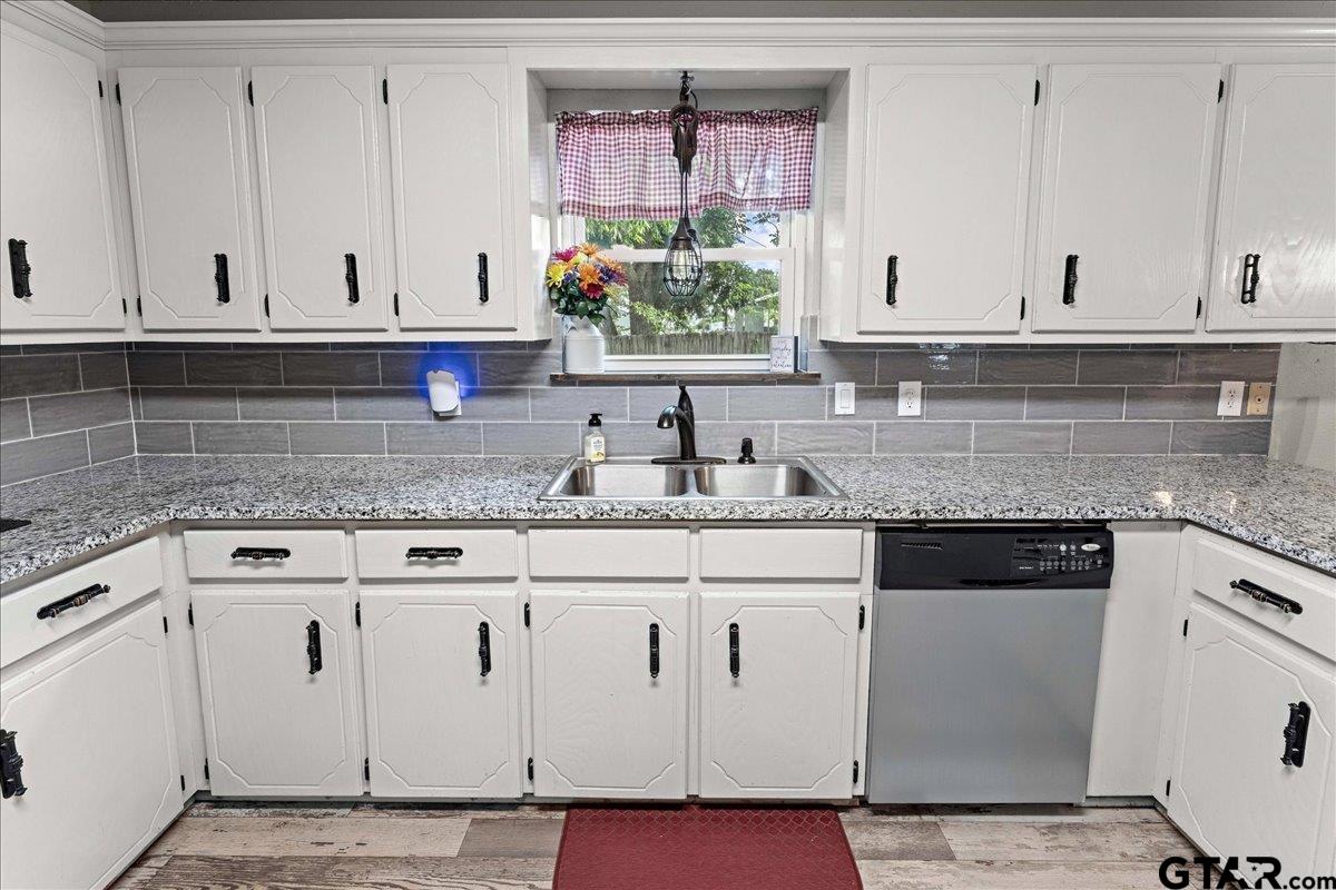 403 Kennedy Street Lindale, TX 75771 - Photo 15 of 36 a kitchen with granite countertop white cabinets and sink