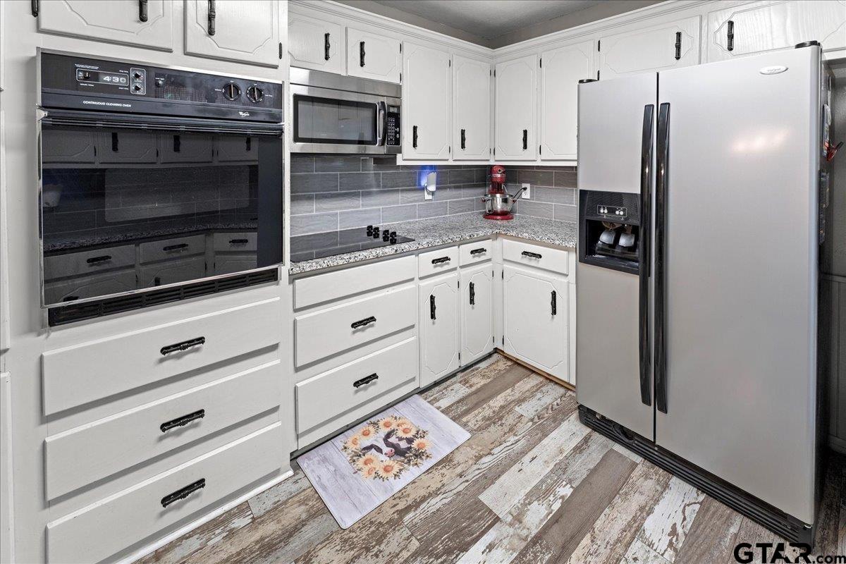 403 Kennedy Street Lindale, TX 75771 - Photo 16 of 36 a kitchen with granite countertop cabinets appliances and a counter space