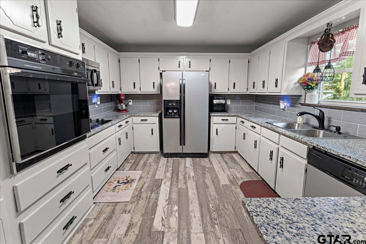 403 Kennedy Street Lindale, TX 75771 - Photo 18 of 36 a kitchen with granite countertop a refrigerator stove and sink
