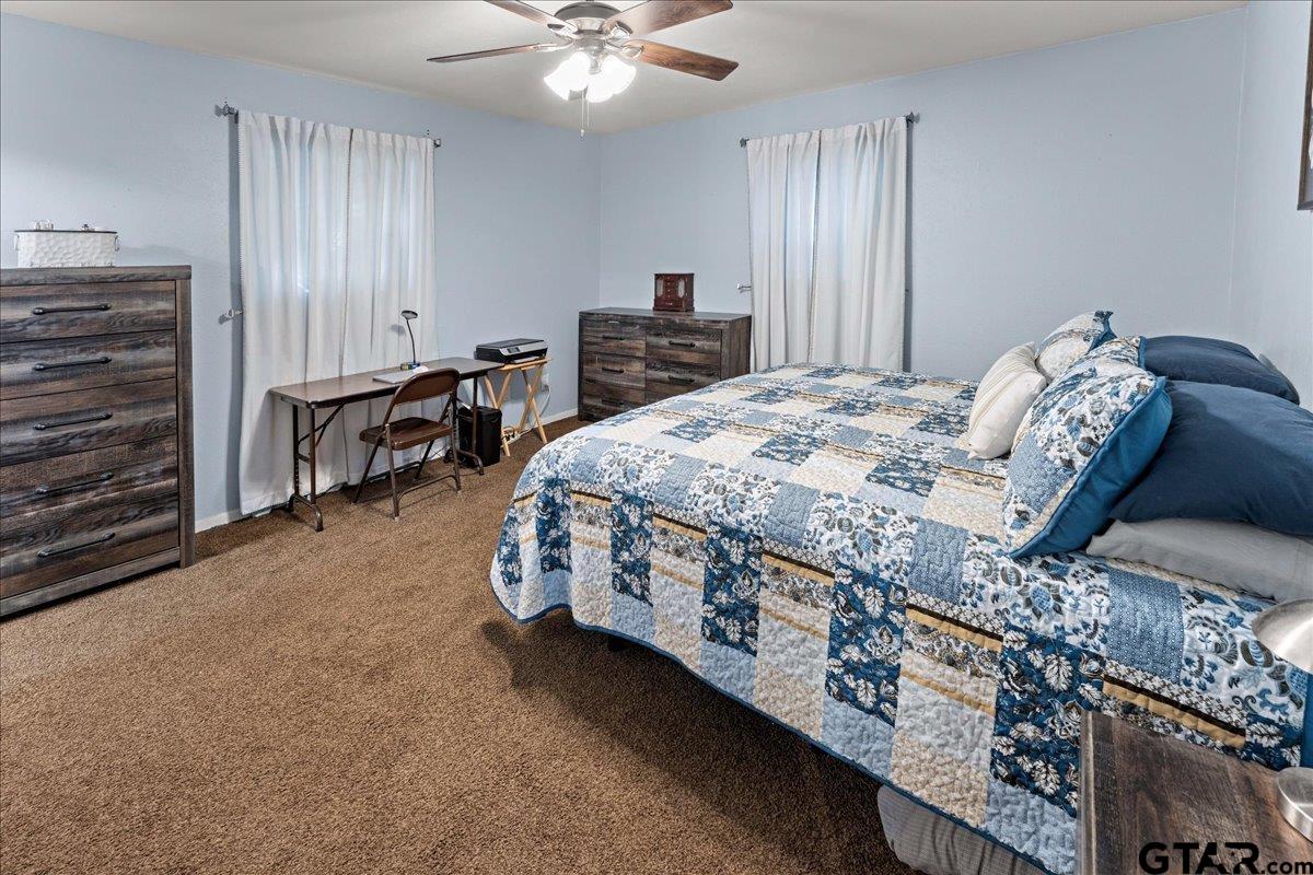 403 Kennedy Street Lindale, TX 75771 - Photo 22 of 36 a bed sitting in a bedroom next to a window and a chandelier