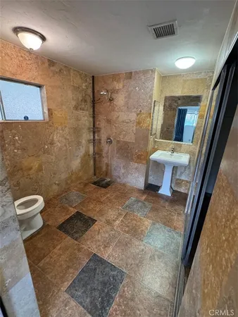 a bathroom with a toilet and a shower