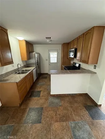 a large kitchen with a sink a microwave and cabinets