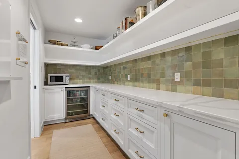 a kitchen with a table chairs refrigerator and microwave