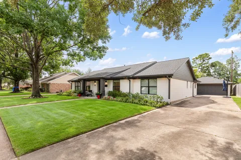a front view of a house with a yard and trees
