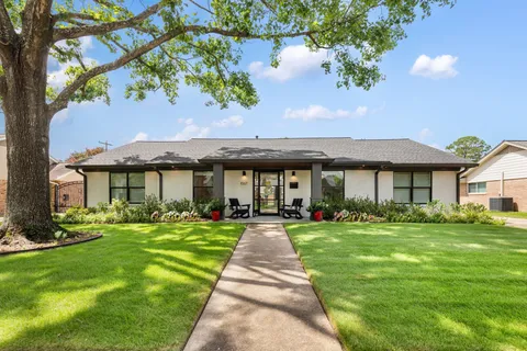 a front view of a house with a yard and potted plants