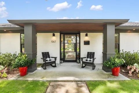 a view of a patio with table and chairs potted plants and a small yard