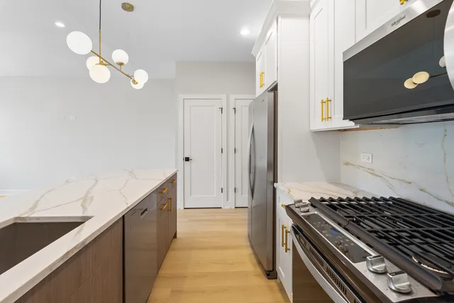 a kitchen with a sink a large window and chandelier