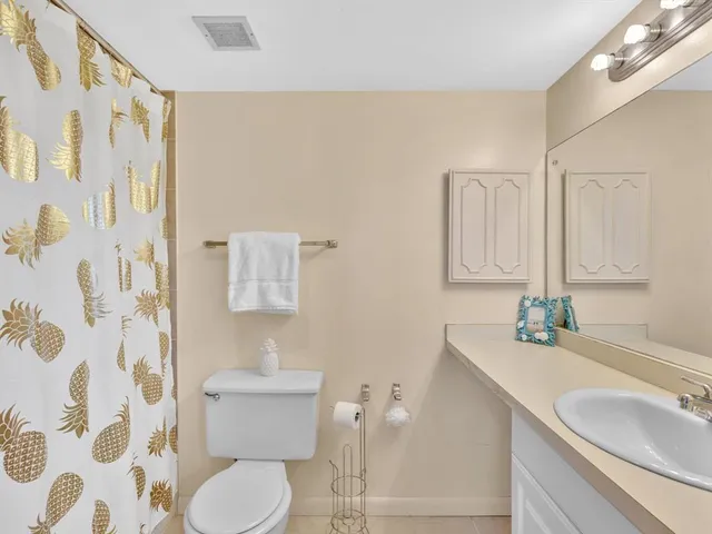 a bedroom with a bed and a lamp on dresser