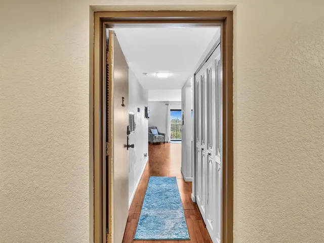 a view of a hallway with wooden floor and staircase