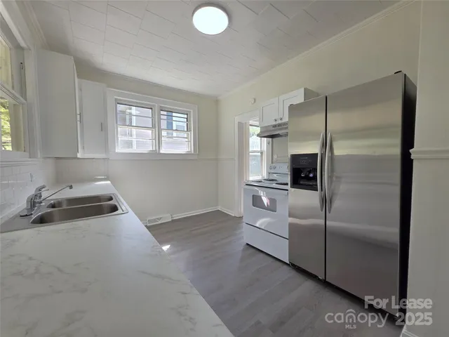 a kitchen with white cabinets and stainless steel appliances