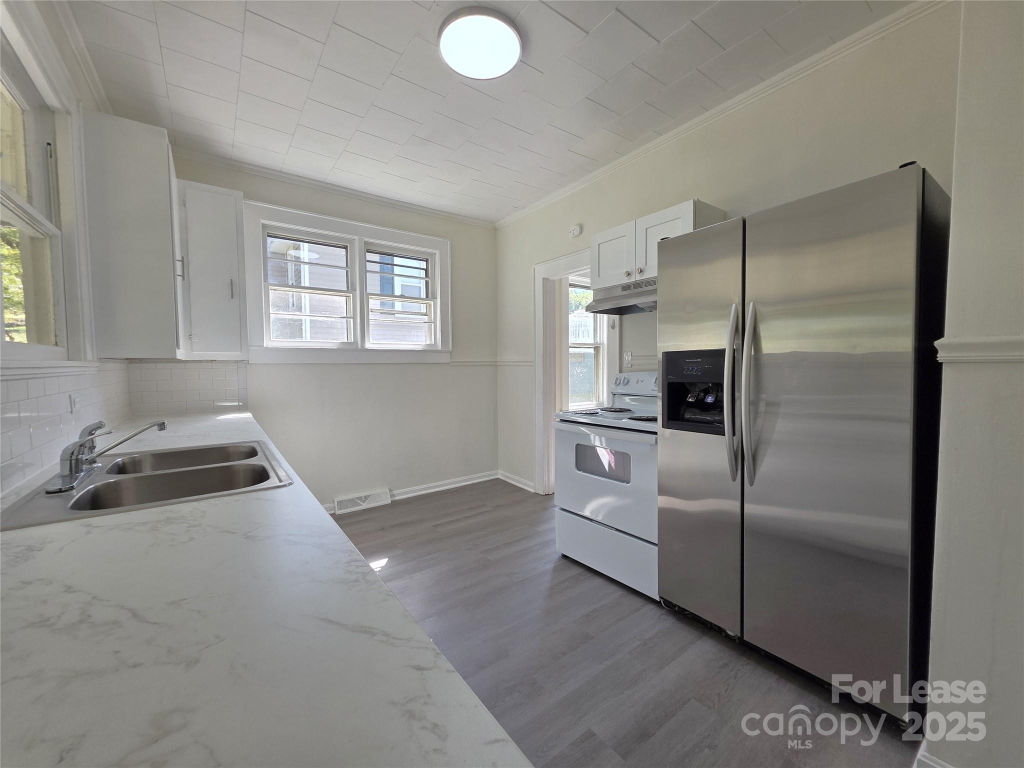 a kitchen with white cabinets and stainless steel appliances