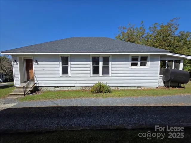 a view of a house with a yard and sitting area