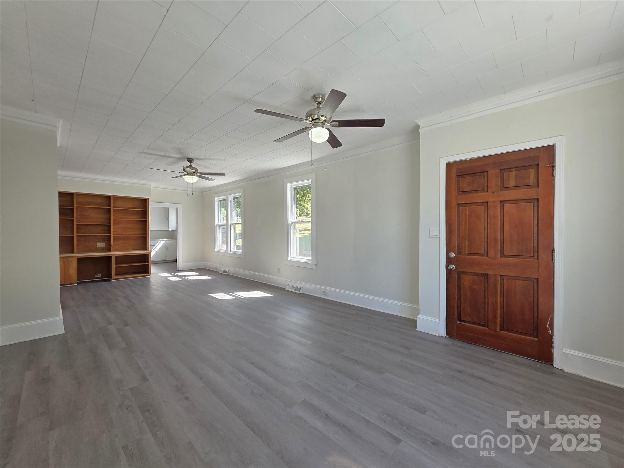106 Falls Road Badin, NC 28009 - Photo 5 of 19 a view of an empty room with a window and wooden floor