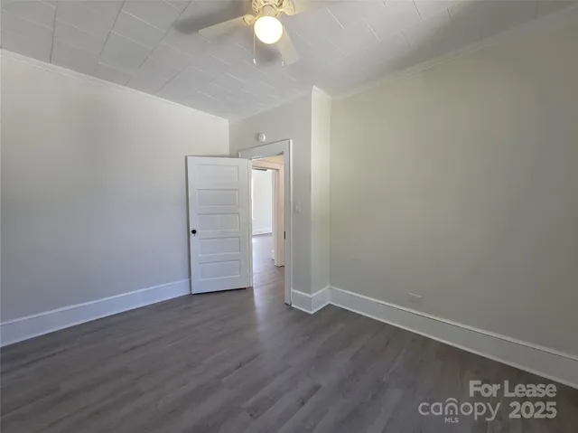 a view of an empty room with wooden floor