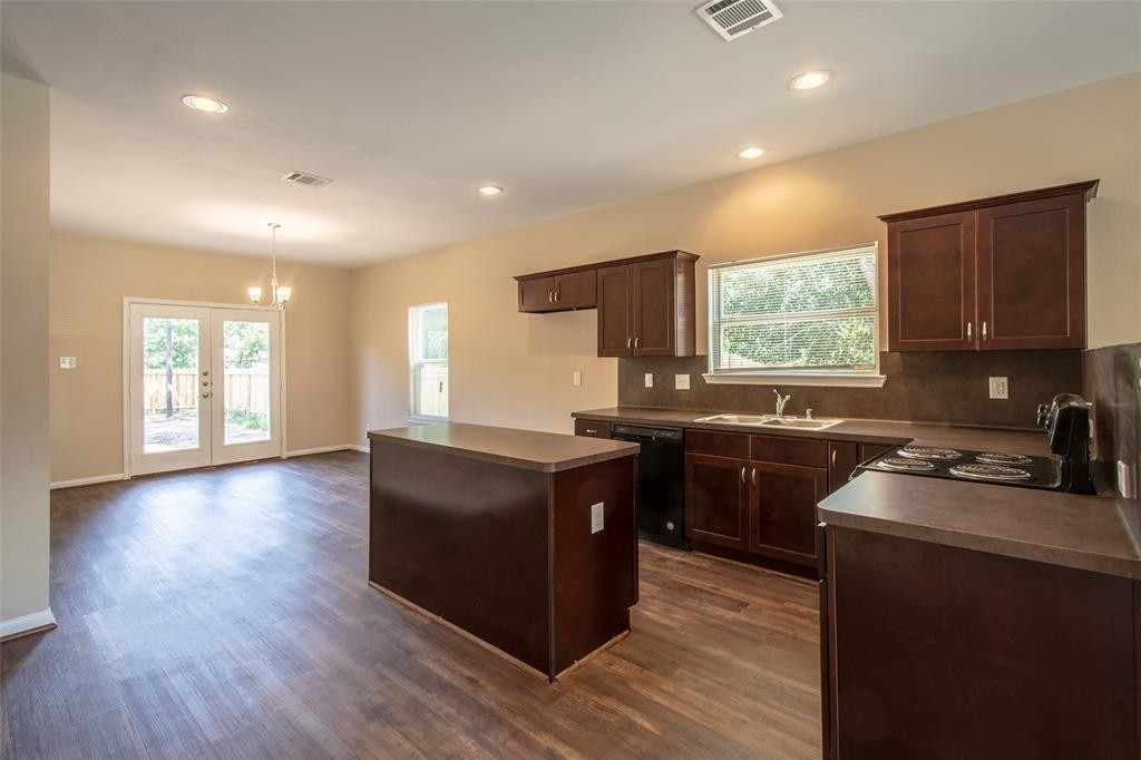 8142 Cabot Street, Unit A Houston, TX 77078 - Photo 5 of 21 a kitchen with granite countertop a stove top oven a sink a counter space and cabinets