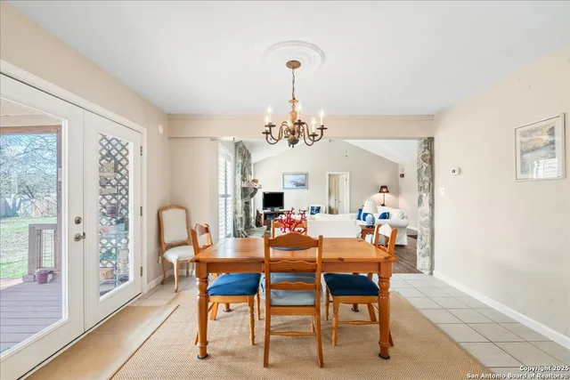 a dining room with furniture a chandelier and a rug