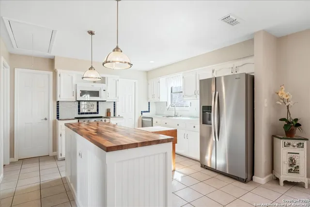 a kitchen with stainless steel appliances granite countertop a refrigerator a sink and a stove