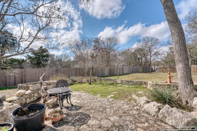 a view of a backyard with table and chairs and a fire pit