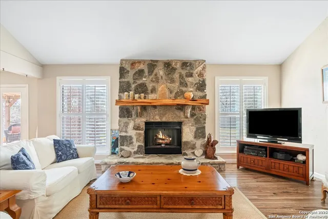 a living room with furniture a flat screen tv and a fireplace