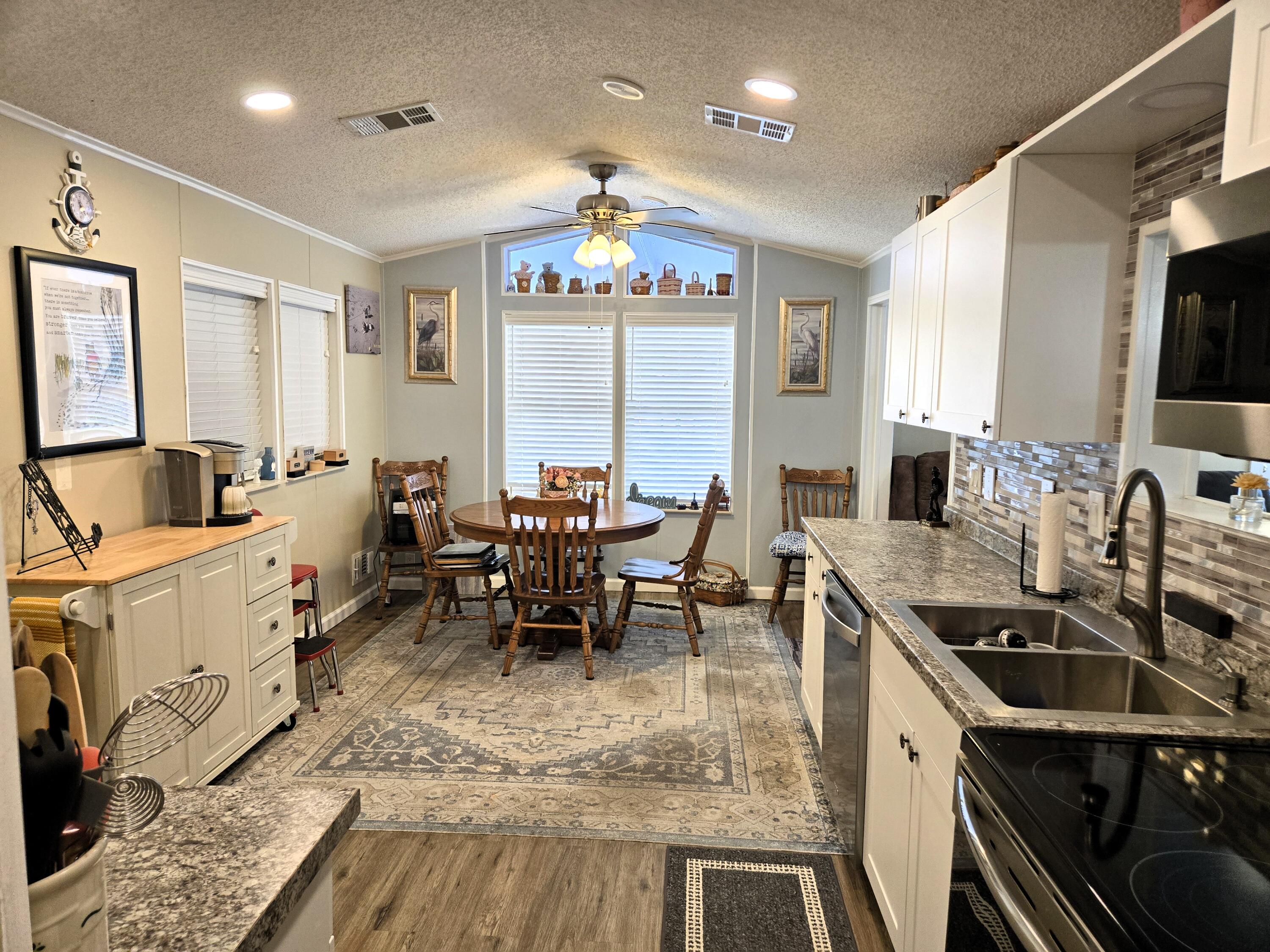 12240 Southeast 138th Avenue, Unit 225 Okeechobee, FL 34974 - Photo 15 of 50 a kitchen with sink refrigerator and dining table