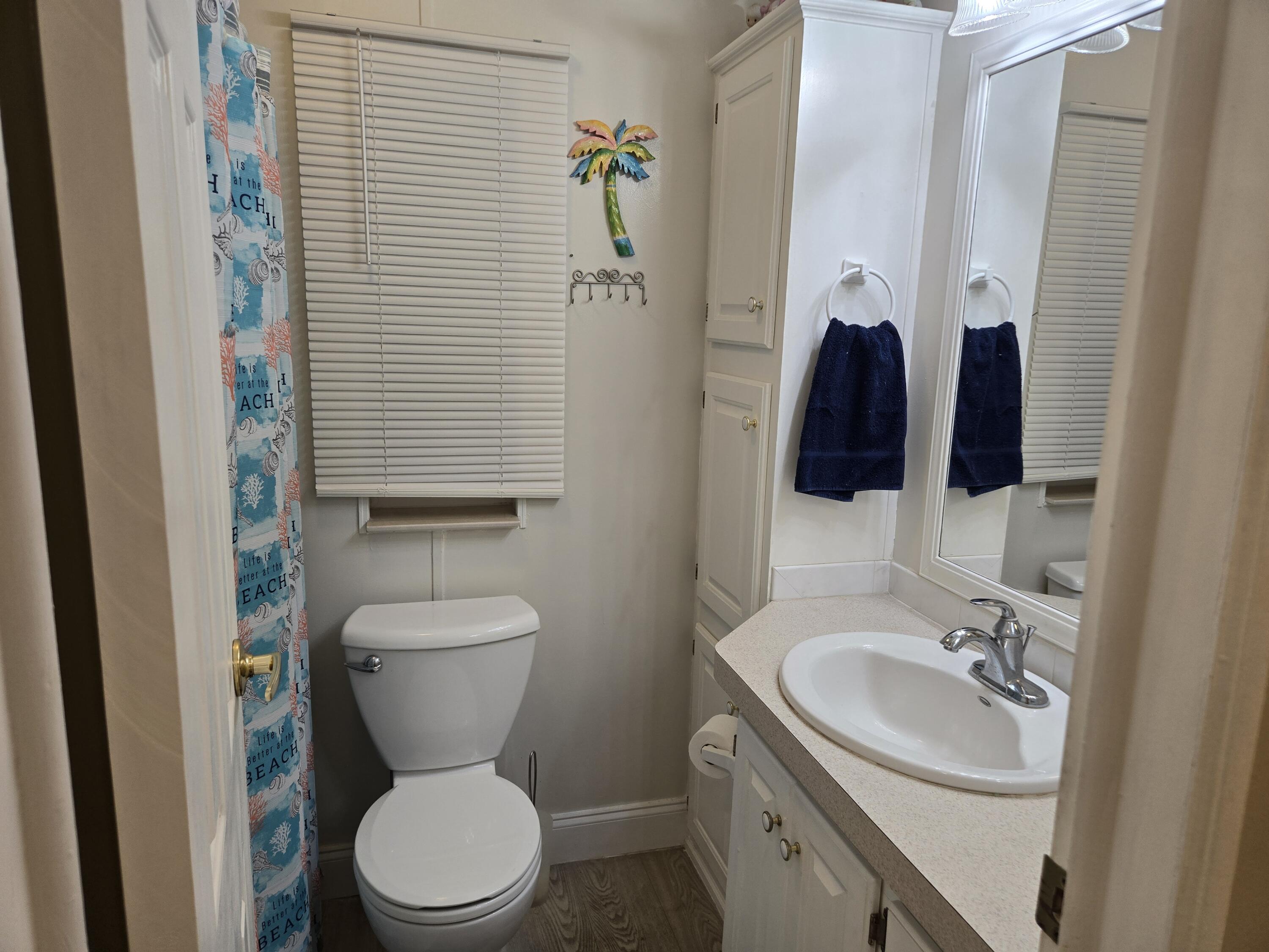12240 Southeast 138th Avenue, Unit 225 Okeechobee, FL 34974 - Photo 18 of 50 a bathroom with a toilet sink and mirror