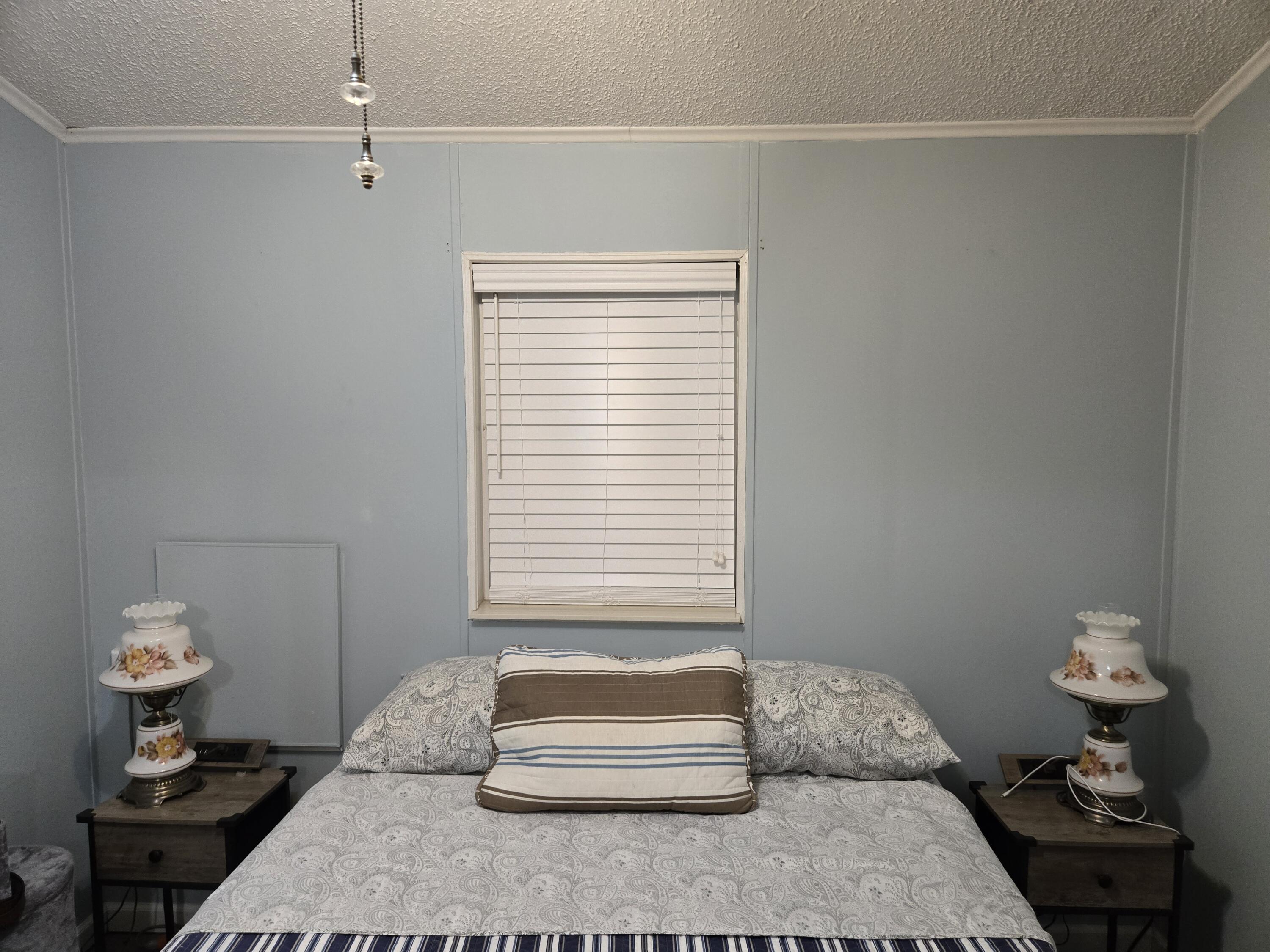 12240 Southeast 138th Avenue, Unit 225 Okeechobee, FL 34974 - Photo 22 of 50 a bedroom with a bed and a chandelier