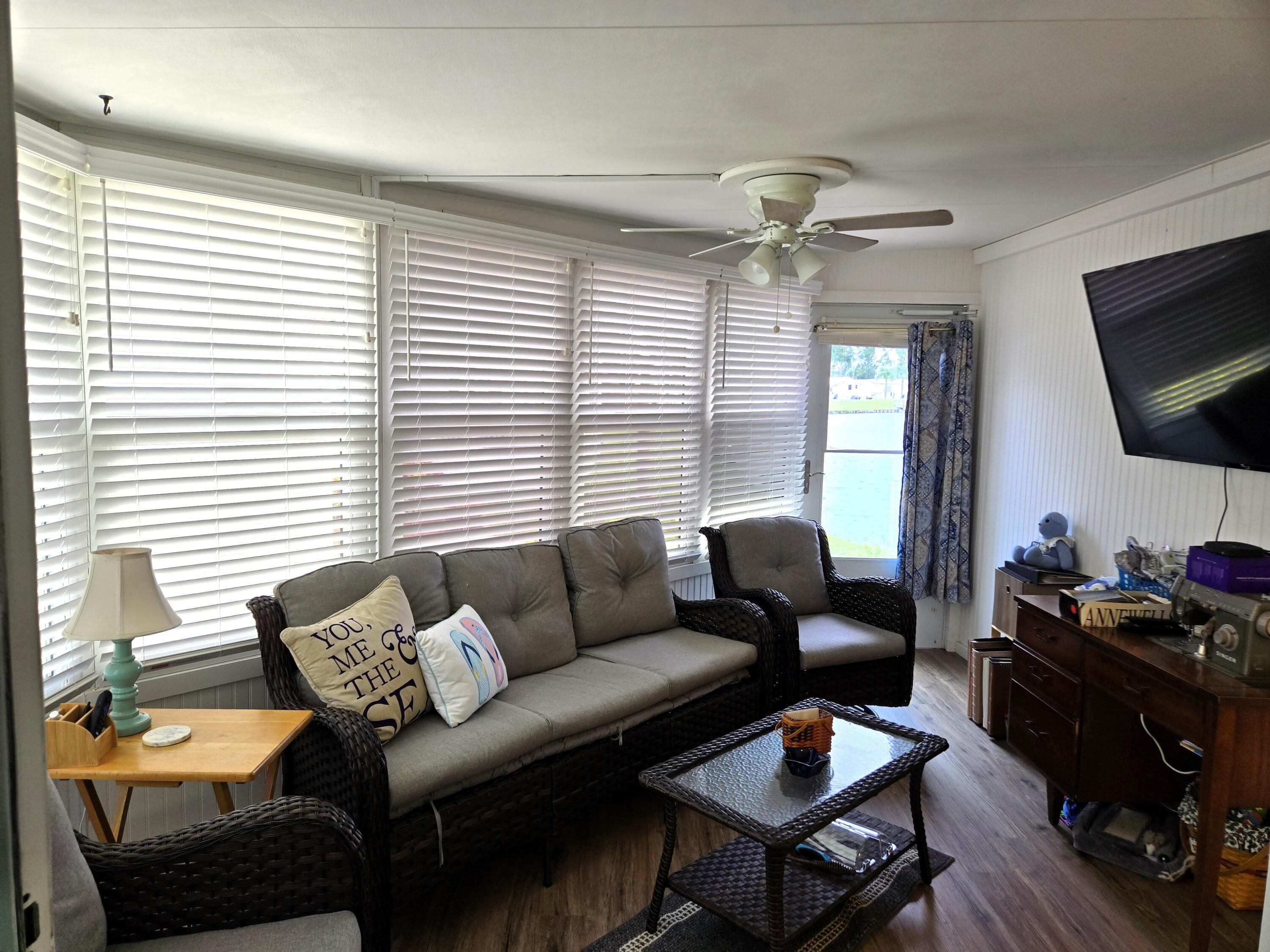 12240 Southeast 138th Avenue, Unit 225 Okeechobee, FL 34974 - Photo 30 of 50 a living room with furniture a flat screen tv and a window