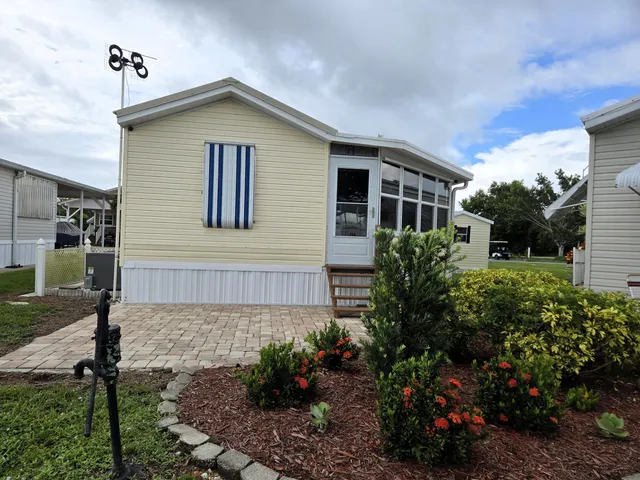 a car parked in front of a house next to a yard