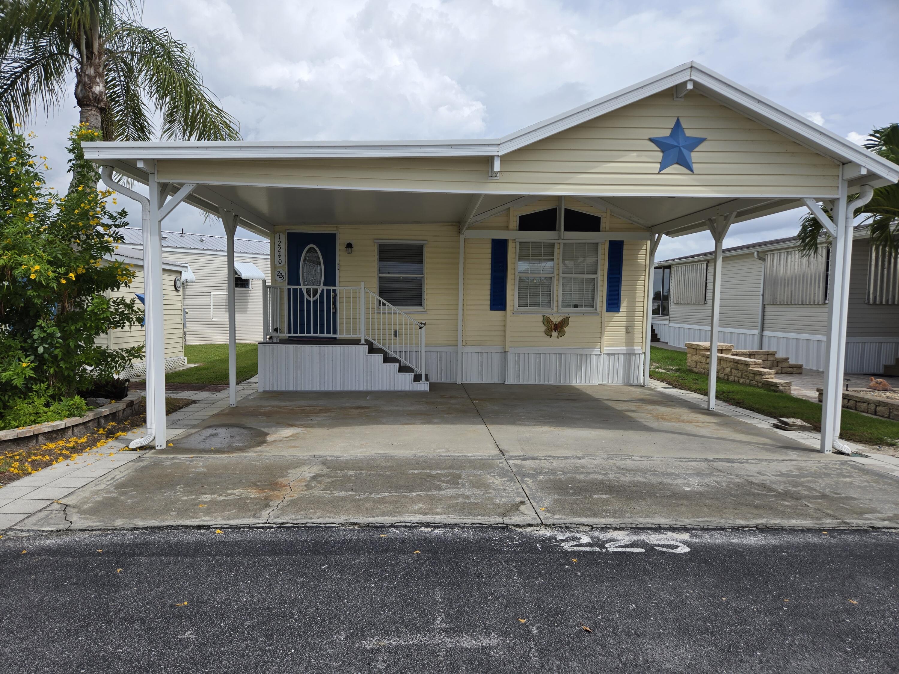 12240 Southeast 138th Avenue, Unit 225 Okeechobee, FL 34974 - Photo 39 of 50 a front view of a house with garden