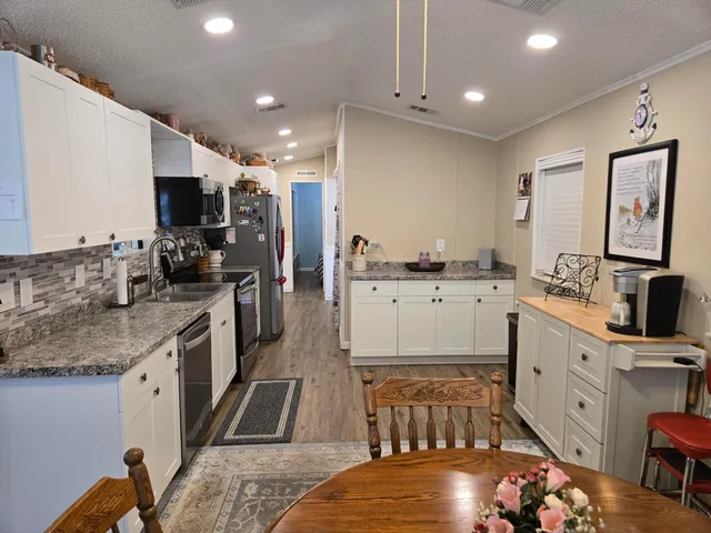 a kitchen with stainless steel appliances granite countertop a sink stove and cabinets