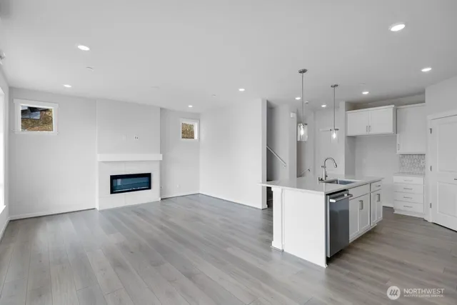 a kitchen with stainless steel appliances granite countertop a stove top oven a sink and a chandelier