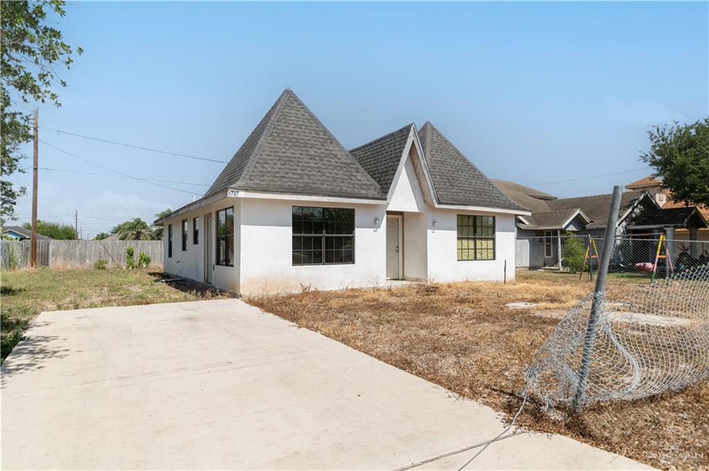 6707 South Rivera Street Pharr, TX 78577 - Photo 2 of 17 View of front facade with stucco siding, roof with shingles, and a fenced backyard