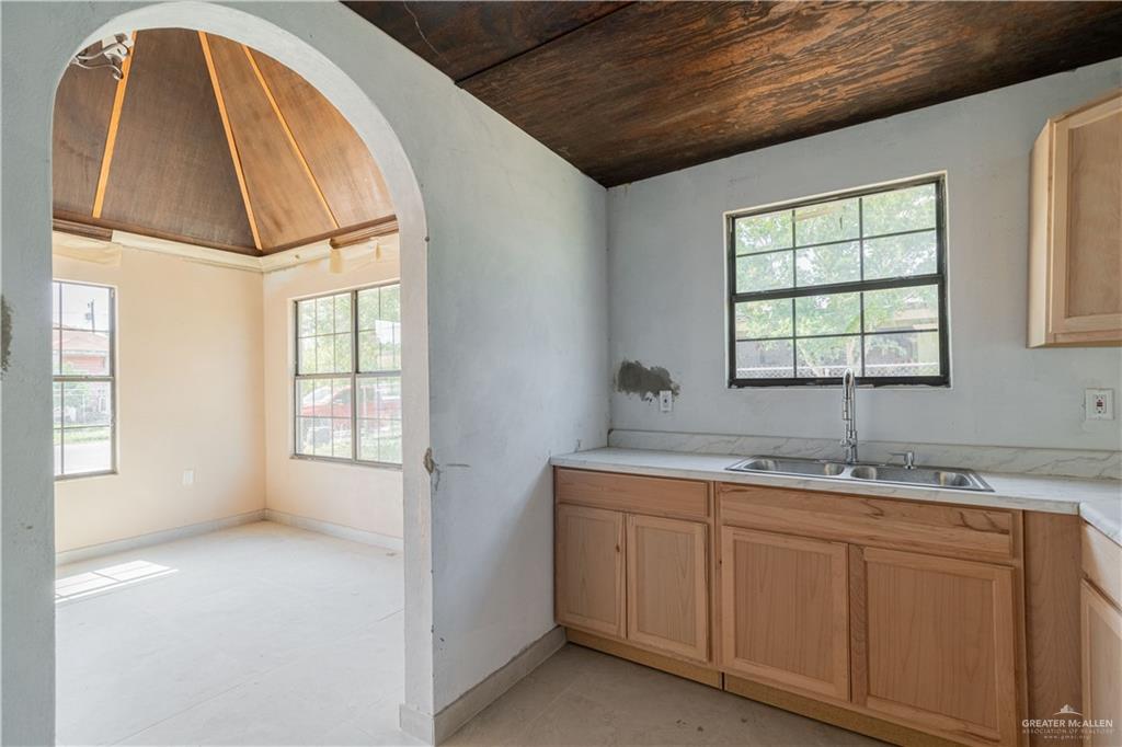 6707 South Rivera Street Pharr, TX 78577 - Photo 6 of 17 Kitchen featuring lofted ceiling, wooden ceiling, arched walkways, light countertops, and light brown cabinets