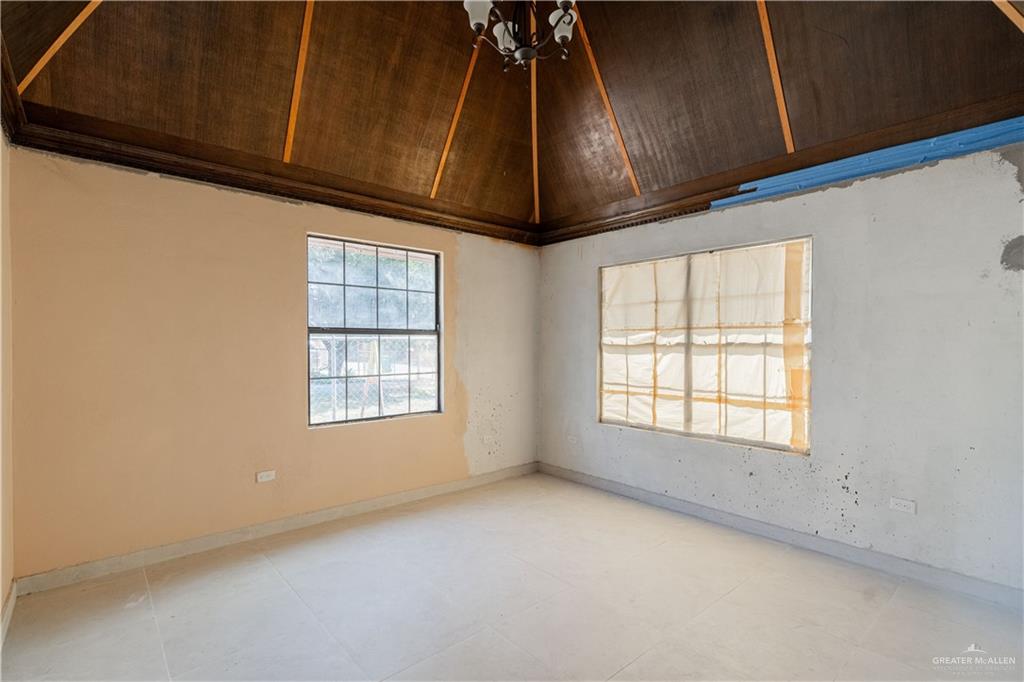 6707 South Rivera Street Pharr, TX 78577 - Photo 8 of 17 Empty room with vaulted ceiling and a chandelier