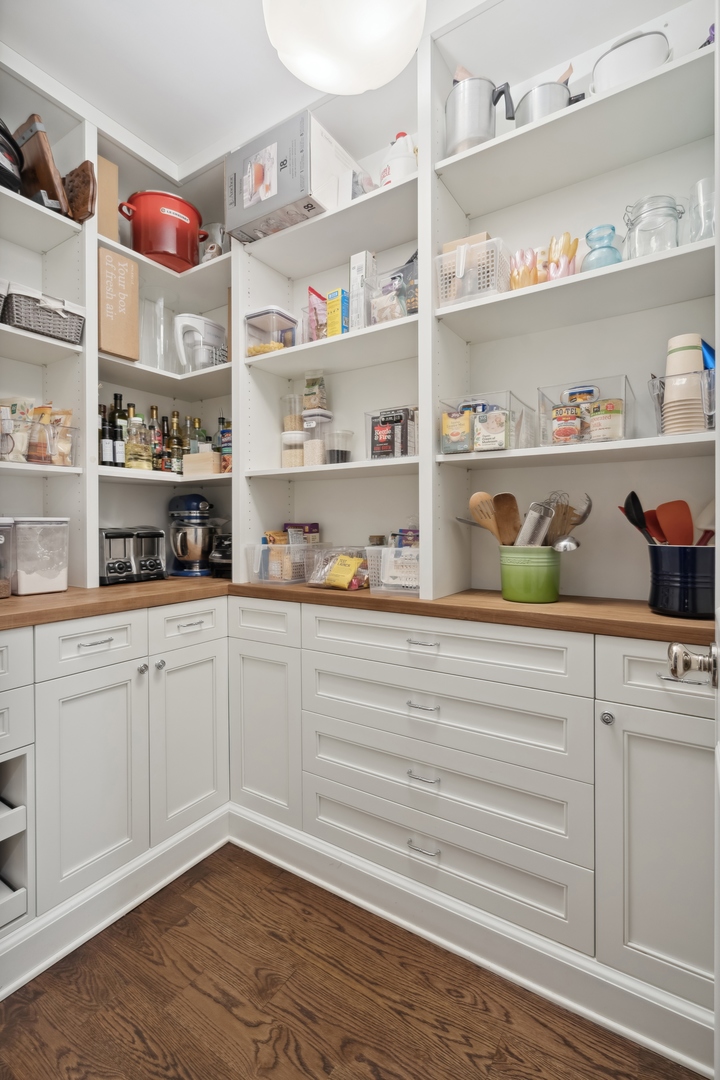 3740 North Wayne Avenue Chicago, IL 60613 - Photo 12 of 55 a kitchen with white cabinets and wooden floor