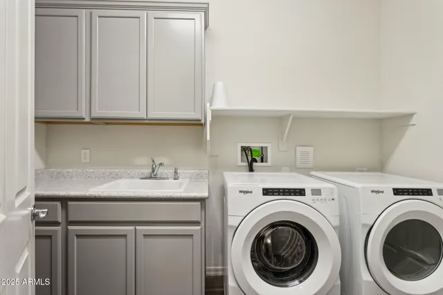 a utility room with sink dryer and washer