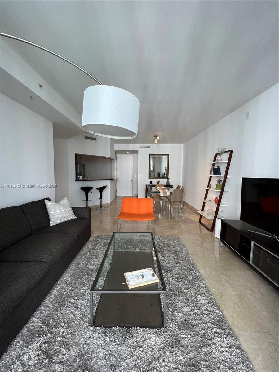 801 Brickell Key Boulevard, Unit 1506 Miami, FL 33131 - Photo 5 of 23 a room with furniture and a flat screen tv