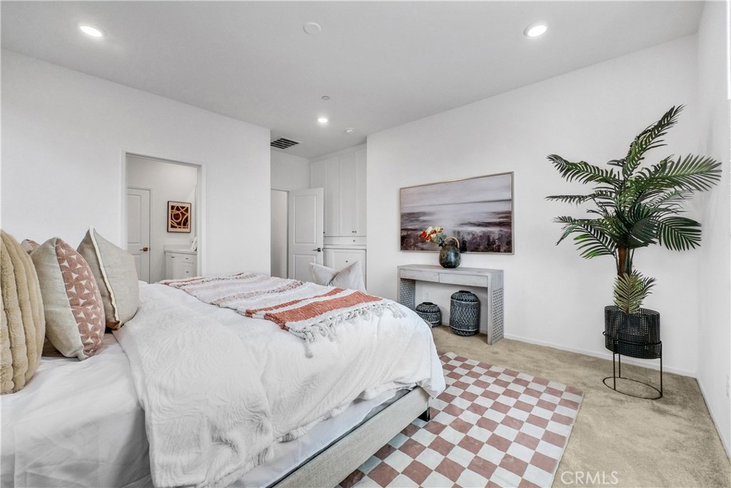 5584 Kate Way, Unit 10 Fontana, CA 92336 - Photo 15 of 42 a bedroom with a large bed and a potted plant