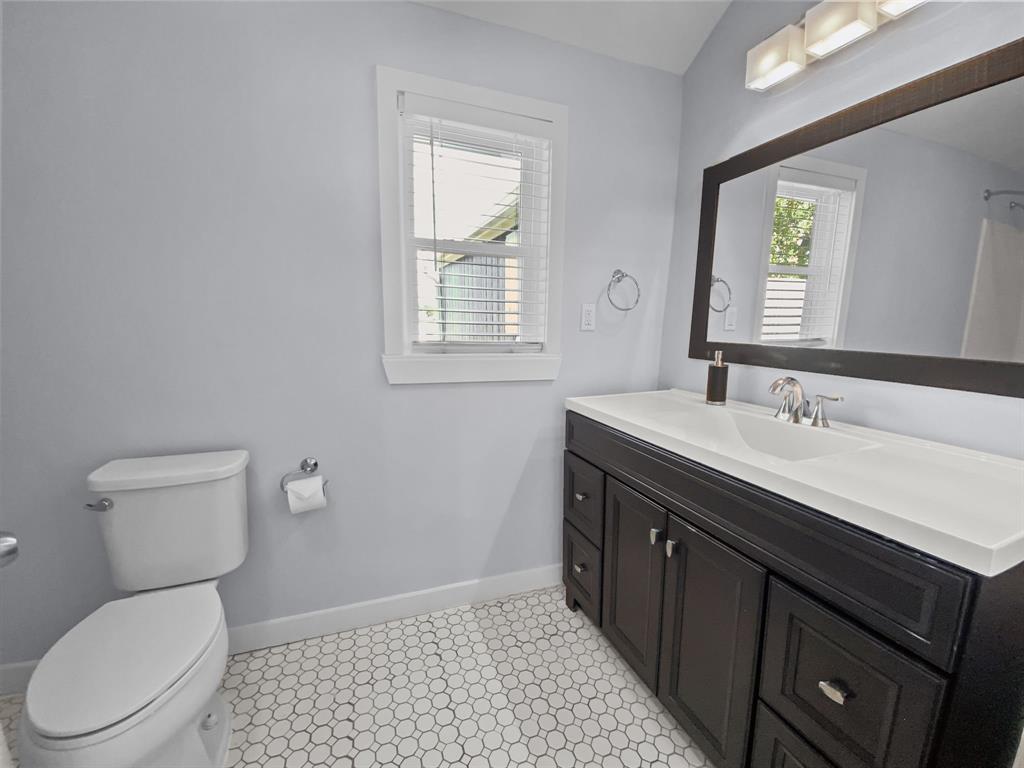 815 Stonecrest Road Argyle, TX 76226 - Photo 6 of 17 Hexagonal tile flooring, dark wood-finish vanity with white countertop, chrome faucet, and a large framed mirror